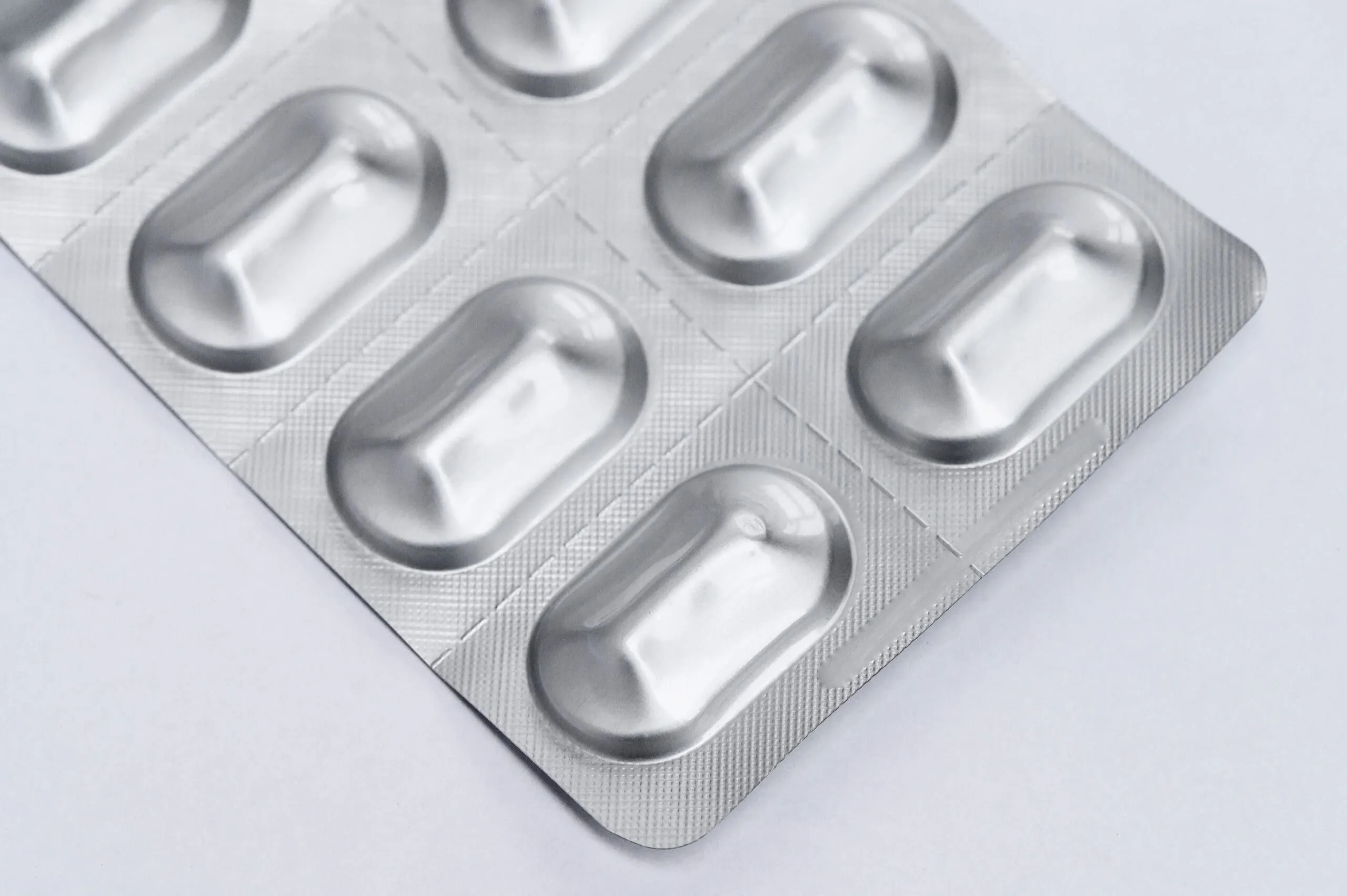 Capsule,pills,medicine,in,silver,aluminium,blister,pack,on,white